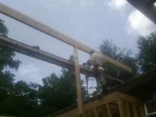 Carpenter setting a ridge beam over a new addition frame — Ice Dam Removal by Roofing Brothers in Jones Mills
